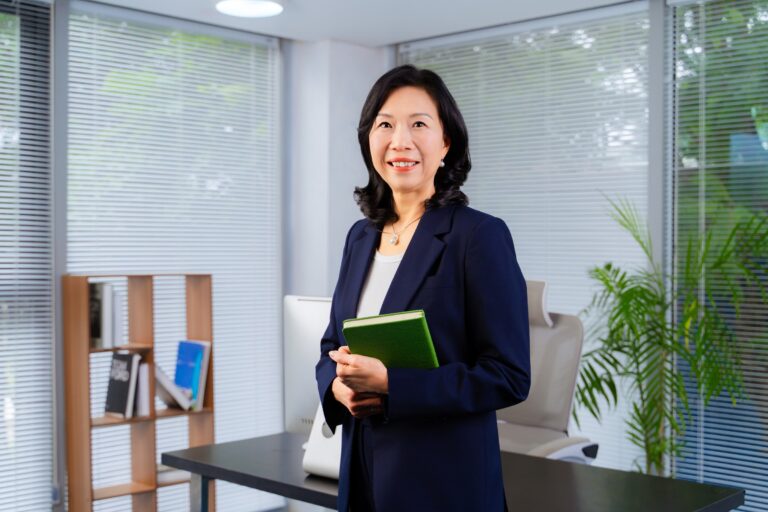 Bà Yong Lai Yin đứng cầm sổ trong bối cảnh văn phòng
